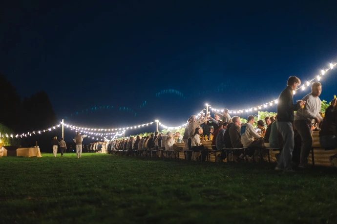 Banquet en plein air de nuit sous une guirlande lumineuse