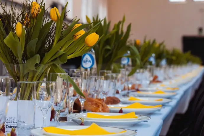 Longue table dressée avec des tulipes et des serviettes jaunes