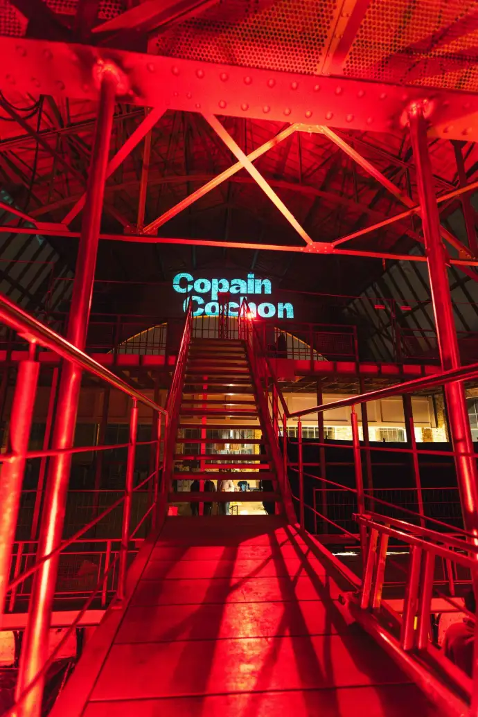 Halle éclairée en rouge avec l'enseigne lumineuse Copain Cochon